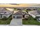 An aerial view of a luxurious residence with a paver driveway, lawn, and picturesque waterfront views at 15344 Serene Shores Loop, Bradenton, FL 34211