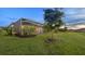 Backyard with screened-in lanai, lush green lawn, trees, and landscaping for outdoor enjoyment at 15344 Serene Shores Loop, Bradenton, FL 34211
