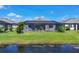 Backyard view showcasing the screened-in pool, lush green lawn, landscaping, and waterfront access at 15344 Serene Shores Loop, Bradenton, FL 34211