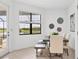 Sunlit dining area featuring a modern table set, large windows with lake views, and access to outdoor space at 15344 Serene Shores Loop, Bradenton, FL 34211