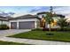 Beautiful home exterior with a three-car garage, lush landscaping, and a well-manicured lawn at 15344 Serene Shores Loop, Bradenton, FL 34211