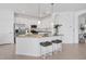 Bright, modern kitchen with white cabinetry, stainless steel appliances, granite counters, and a large island with seating at 15344 Serene Shores Loop, Bradenton, FL 34211