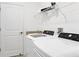 Well-lit laundry room with modern appliances, granite countertop, storage shelves, and a white interior door at 15344 Serene Shores Loop, Bradenton, FL 34211