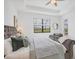 Spacious main bedroom with plush bed, sitting area, and view of pool/lake area through a large window at 15344 Serene Shores Loop, Bradenton, FL 34211