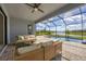 Covered patio with comfortable seating, ceiling fan, and a view of the screened pool and lake at 15344 Serene Shores Loop, Bradenton, FL 34211