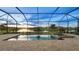 Stunning view of a screened pool and hot tub overlooking a serene lake at sunset at 15344 Serene Shores Loop, Bradenton, FL 34211