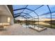 Outdoor screened-in pool area with hot tub and serene view of the lake at sunset at 15344 Serene Shores Loop, Bradenton, FL 34211