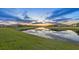 Beautiful waterfront view reflecting a colorful sky over the surrounding neighborhood homes at 15344 Serene Shores Loop, Bradenton, FL 34211