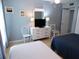 Bright bedroom with white furnishings, two twin beds, and calming blue walls at 1801 Gulf N Dr # 207, Bradenton Beach, FL 34217