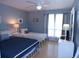 Comfortable bedroom features two twin beds, light wood floors, and calming blue walls at 1801 Gulf N Dr # 207, Bradenton Beach, FL 34217
