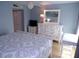 Bedroom featuring a white dresser, mirror, side tables, and bed with decorative bedding and accents at 1801 Gulf N Dr # 207, Bradenton Beach, FL 34217