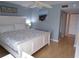 Bedroom showcasing a white bed with patterned bedding, a side table, artwork, and a ceiling fan at 1801 Gulf N Dr # 207, Bradenton Beach, FL 34217