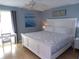 Bedroom view displaying a white bed with patterned bedding and a matching side table and decor at 1801 Gulf N Dr # 207, Bradenton Beach, FL 34217