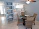 Dining area with a round glass table, wicker chairs, and adjacent breakfast bar at 1801 Gulf N Dr # 207, Bradenton Beach, FL 34217
