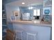 Galley kitchen area featuring white cabinetry and a breakfast bar with seating at 1801 Gulf N Dr # 207, Bradenton Beach, FL 34217