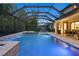 Evening shot of a pool in screened lanai, with poolside seating and a dining area, well-lit and inviting at 19351 Ranchview Ct, Land O Lakes, FL 34638