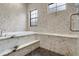A modern bathroom features decorative tile, marble accents and a built in tub at 19351 Ranchview Ct, Land O Lakes, FL 34638