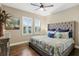 Bedroom with hardwood floors, a decorative upholstered headboard and bright natural light at 19351 Ranchview Ct, Land O Lakes, FL 34638