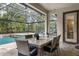Screened lanai features a dining area with wicker furniture overlooking the backyard pool and landscaped area at 19351 Ranchview Ct, Land O Lakes, FL 34638