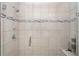 Glass enclosed shower with bench, decorative tile, and chrome fixtures at 2108 Citrus Breeze Dr, Bradenton, FL 34208