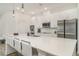 Modern kitchen with white cabinetry, a large center island with seating, and stainless steel appliances at 2108 Citrus Breeze Dr, Bradenton, FL 34208