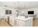 Modern kitchen island with stainless steel appliances, quartz countertops, and an open-concept layout to living area at 2108 Citrus Breeze Dr, Bradenton, FL 34208