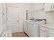 Functional laundry room with modern washer and dryer, overhead shelving, and a convenient folding bench at 2108 Citrus Breeze Dr, Bradenton, FL 34208