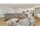 Large living room with an open floor plan, showcasing modern furniture, light hardwood flooring, and recessed lighting at 2108 Citrus Breeze Dr, Bradenton, FL 34208