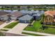 Aerial view of a blue house surrounded by well-maintained landscaping and lake in the background at 2347 123Rd E Pl, Parrish, FL 34219