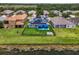 Aerial shot of backyard with solar panels, fenced yard, lake, fire pit and lush landscaping at 2347 123Rd E Pl, Parrish, FL 34219