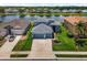 Birds-eye view of blue house with lush green lawn with lake in the background at 2347 123Rd E Pl, Parrish, FL 34219