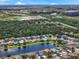 An aerial view of the community showcasing a pond surrounded by cozy homes in a verdant setting at 2347 123Rd E Pl, Parrish, FL 34219