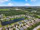 A picturesque aerial view of a suburban neighborhood with a tranquil pond and well-maintained homes at 2347 123Rd E Pl, Parrish, FL 34219