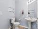 Stylish half bathroom with pedestal sink, tiled floors, floating glass shelves, and modern fixtures at 2347 123Rd E Pl, Parrish, FL 34219