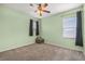 Bedroom with carpet, green walls, and natural light from the windows with black curtains at 2347 123Rd E Pl, Parrish, FL 34219