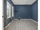 Bedroom featuring wood-look floors, modern curtains, blue walls, and a window for natural light at 2347 123Rd E Pl, Parrish, FL 34219