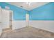 Bright bedroom with blue accent wall, carpet, and doorway to the hallway at 2347 123Rd E Pl, Parrish, FL 34219