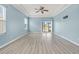 Bright bedroom with wood-look floors, light blue walls, tray ceiling, and sliding glass door at 2347 123Rd E Pl, Parrish, FL 34219