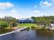 View of a blue community center with pier access, surrounded by lush vegetation and serene waters at 2347 123Rd E Pl, Parrish, FL 34219
