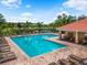 This aerial shows the community pool with a red tile roofed building, seating, palm trees, and pristine waters at 2347 123Rd E Pl, Parrish, FL 34219