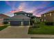 Charming two-story home boasts a three-car garage, manicured lawn, and a welcoming entrance at 2347 123Rd E Pl, Parrish, FL 34219
