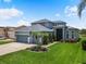 Beautiful two-story home with lush landscaping, a three-car garage, and a well-manicured lawn at 2347 123Rd E Pl, Parrish, FL 34219
