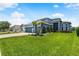 Blue two-story home featuring well-manicured lawn, and lush landscaping at 2347 123Rd E Pl, Parrish, FL 34219