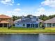 View of blue house from the backyard, showing solar panels on the roof and a screened in patio at 2347 123Rd E Pl, Parrish, FL 34219