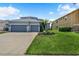 Charming two-story home boasts a three-car garage, manicured lawn, and beautiful front yard at 2347 123Rd E Pl, Parrish, FL 34219