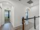 Bright hallway with an archway and black and white railing leading to a carpeted staircase at 2347 123Rd E Pl, Parrish, FL 34219