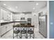 A view of a kitchen with white cabinets, stainless steel appliances, an island with seating, and marble patterned flooring at 2347 123Rd E Pl, Parrish, FL 34219