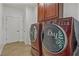 A laundry room featuring a matching washer and dryer set with cabinets above, located off of the hallway at 2347 123Rd E Pl, Parrish, FL 34219