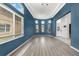 Bright living room with beautiful trim, multiple windows with curtains, and gray floors at 2347 123Rd E Pl, Parrish, FL 34219