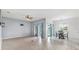 Bright living room with light-toned wood floors, ceiling fan, and sliding doors to the outside at 2347 123Rd E Pl, Parrish, FL 34219